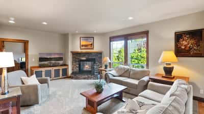 Bright and inviting living room featuring a cozy fireplace and large windows that illuminate the space.