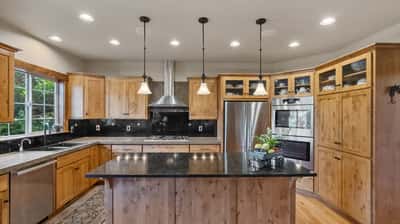 This spacious kitchen features wooden cabinetry, modern appliances, and ample natural light, perfect for culinary enthusiasts.