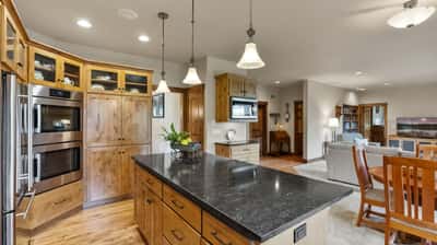 Modern kitchen featuring warm wood cabinetry, sleek countertops, and open layout ideal for entertaining and everyday living.