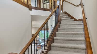 Ascend this beautifully crafted staircase leading to inviting living spaces filled with natural light.