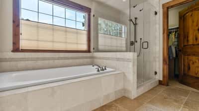 Experience modern living in this inviting bathroom, featuring a spacious soaking tub and walk-in shower.