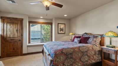 Cozy bedroom featuring a comfortable bed, ample natural light, and unique lighting fixtures for a warm ambiance.