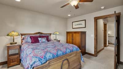 Cozy bedroom featuring classic furnishings, warm lighting, and ample space for relaxation and personalization.