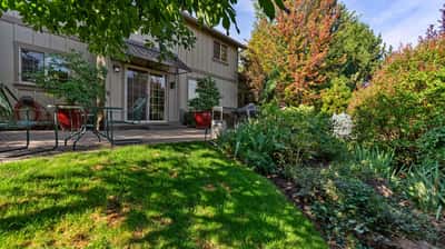 Discover a spacious backyard oasis featuring landscaped gardens and inviting patio areas for outdoor gatherings.