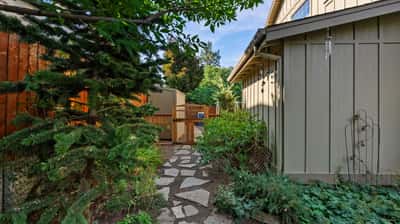 Discover a unique outdoor pathway leading to inviting spaces, surrounded by lush greenery and natural beauty.