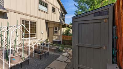 Discover this inviting backyard space featuring raised garden beds and a practical storage shed for your needs.