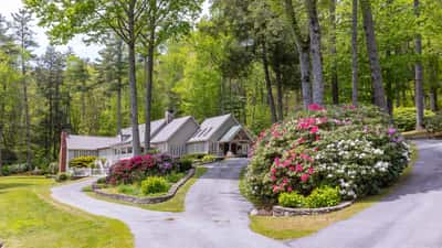 Nestled among lush greenery, this stunning property features expansive gardens and a winding driveway for added privacy.