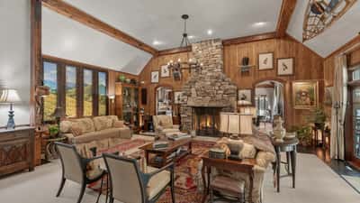 Spacious living area featuring a stunning stone fireplace and large windows with picturesque mountain views.
