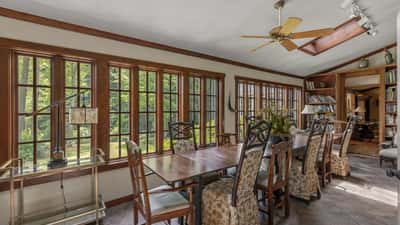 Bright sunroom with expansive windows, perfect for dining and enjoying garden views year-round.