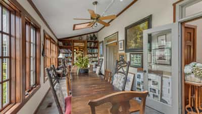Bright and inviting dining area features ample natural light, a spacious table, and built-in bookshelves.