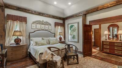 Bright and inviting bedroom featuring warm wood accents and an adjoining vanity area for convenience.