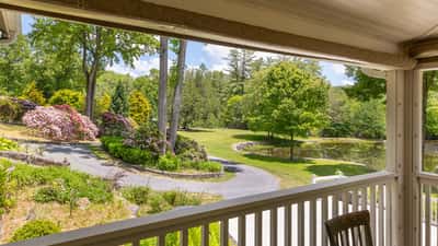 Enjoy picturesque views from the porch, featuring lush gardens and a tranquil pond in a private setting.