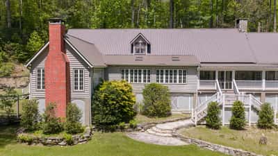 Nestled among trees, this unique property features ample outdoor space and distinctive architectural details.