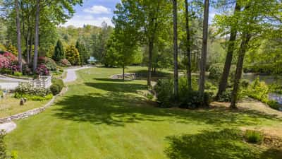 Spacious grounds feature lush greenery and a tranquil pond, perfect for outdoor gatherings and relaxation.