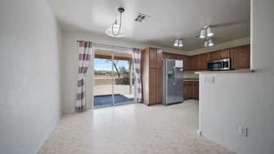 Dining area enjoys abundant natural light and sliding glass door access to the backyard, creating a pleasant setting for meals while overlooking the peaceful desert landscape and mountain views.