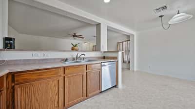Open kitchen connects effortlessly to the dining and living areas with a convenient breakfast bar. Abundant cabinetry, stainless steel appliances, and spacious countertops create an inviting gathering place.