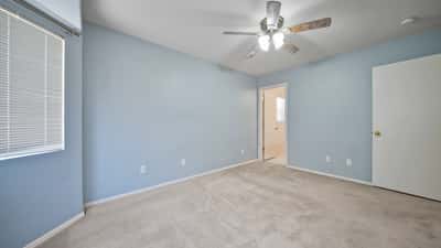 Alternate view highlights the generous proportions of the primary bedroom with easy access to the walk-in closet and private bathroom. Natural light and neutral finishes create a warm, welcoming space.