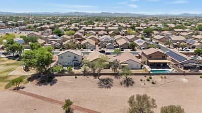Aerial neighborhood view highlights the home's desirable setting near open space, walking paths, and surrounding Buckeye scenery while showcasing the property's convenient location.