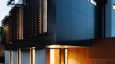 Modern architectural masterpiece featuring sleek lines, contrasting materials, and inviting entrance in a serene setting.
