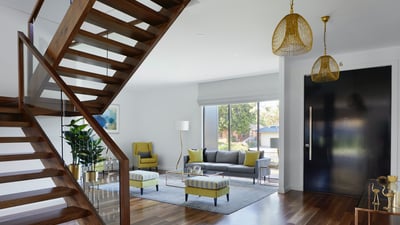 Stylish, modern interior with elegant staircase, spacious living area, and abundant natural light. Perfect for entertaining!