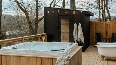 Discover a private outdoor oasis featuring a relaxing hot tub and a secluded sauna amid scenic woodlands.