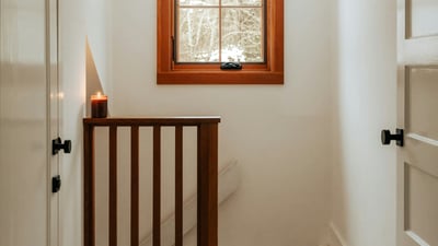 Bright and inviting hallway featuring natural light, wood accents, and a cozy atmosphere.