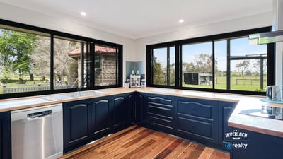Modern kitchen with panoramic windows, featuring sleek cabinetry and scenic views of the surrounding landscape.