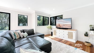 Spacious living area features large windows, modern furnishings, and ample natural light for a welcoming atmosphere.