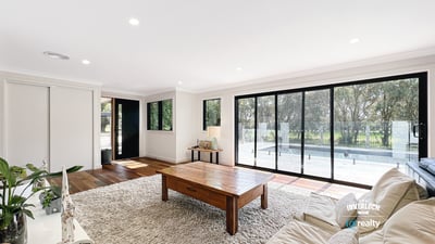 Spacious living area features large windows, abundant natural light, and direct access to outdoor spaces.