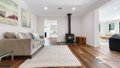Spacious living area featuring natural light, modern decor, and a cozy fireplace, perfect for gatherings.