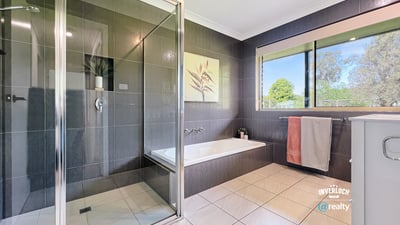 Modern bathroom featuring sleek tiles, a spacious shower, and large windows for natural light.