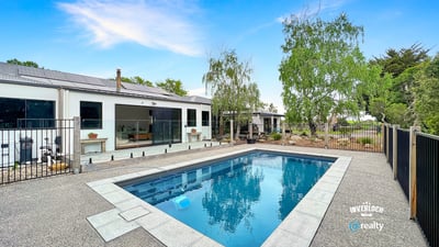 This contemporary home features a spacious outdoor area with a pristine pool and landscaped surroundings.