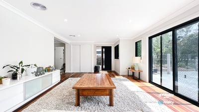 Bright open living space featuring large windows, natural light, and a warm wood coffee table.