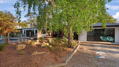 Contemporary home surrounded by lush landscaping, featuring spacious outdoor areas and modern design elements.