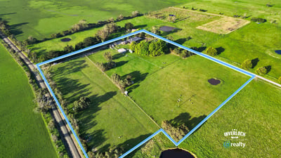 Spacious rural property featuring open fields, ponds, and mature trees, offering endless possibilities for development.