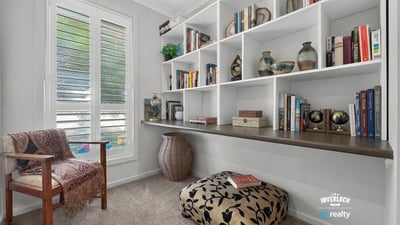 This inviting nook features a custom shelving unit, perfect for book lovers and cozy reading moments.
