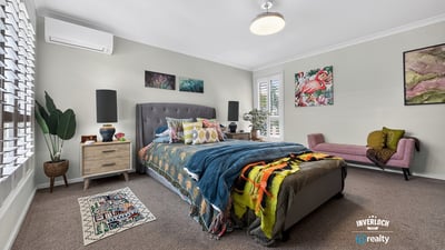 Spacious bedroom featuring modern décor, ample natural light, and cozy accents for a welcoming atmosphere.