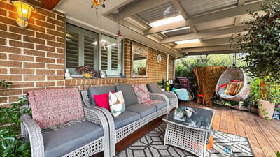 Discover a cozy outdoor retreat featuring comfortable seating and vibrant greenery, perfect for relaxing gatherings.