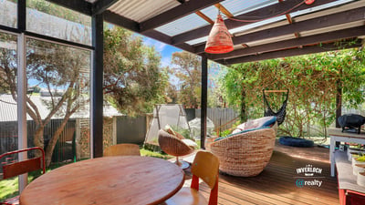 Relax in this inviting outdoor space with a cozy seating area, surrounded by lush greenery.