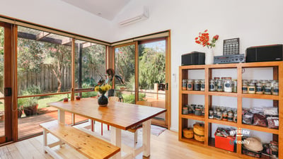 Bright dining space featuring natural light, an open layout, and direct access to a lush outdoor area.