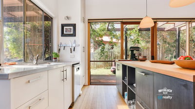 Modern kitchen with natural light, featuring sleek cabinetry and direct access to a spacious outdoor area.