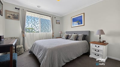 Spacious bedroom featuring natural light, cozy furnishings, and a tranquil atmosphere ideal for relaxation.