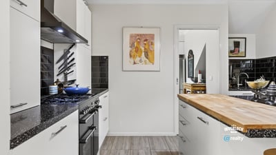 Modern kitchen featuring sleek appliances, ample counter space, and distinct artwork for a vibrant touch.