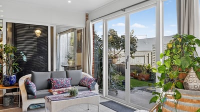 Bright and airy sunroom featuring large windows, perfect for relaxation and enjoying views of the garden.