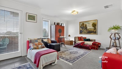 Spacious living area features abundant natural light, unique decor elements, and cozy textiles perfect for gatherings.
