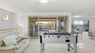 Spacious recreational area with a foosball table and large windows showcasing captivating outdoor views.