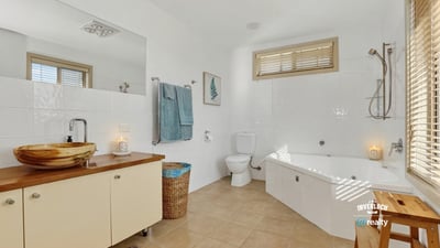 Spacious bathroom featuring a bathtub, modern fixtures, ample light, and thoughtful storage solutions for convenience.