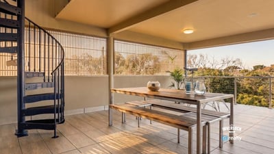 Spacious outdoor terrace featuring a spiral staircase, perfect for entertaining and enjoying panoramic views.