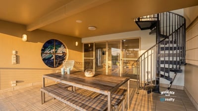 Enjoy outdoor living on this spacious patio featuring a spiral staircase and captivating views.