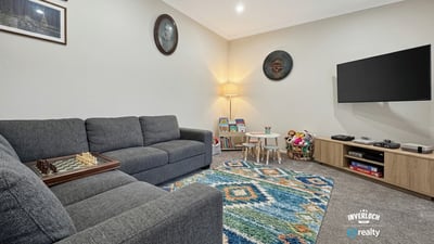 Bright, inviting living area featuring modern furnishings, a playful rug, and ample natural light throughout.